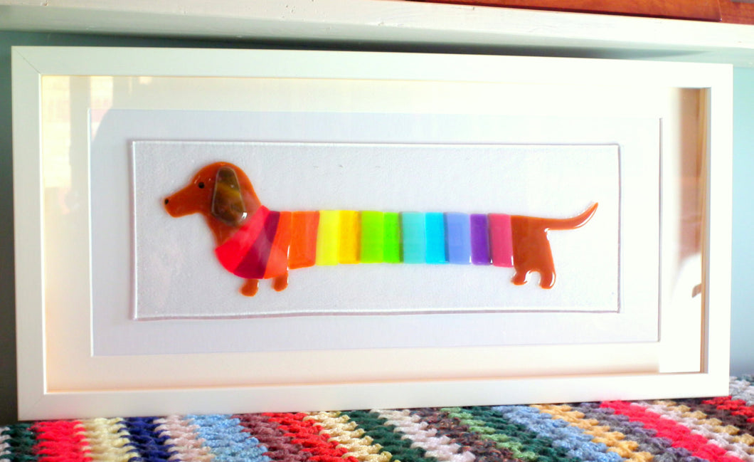Solid glass, fused glass picture of dachshund wearing rainbow striped jumper. Framed glass wall art